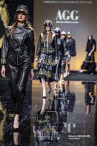 Il celebre couturier Anton Giulio Grande ha incantato il pubblico della Milano Fashion Week con la sua nuova collezione "AGG on the road", presentata il 25 febbraio 2025 presso la Fiera Milano Rho. La sfilata ha celebrato i venticinque anni di carriera del designer calabrese, famoso per la sua maestria nell'haute couture. Ispirazione e Concept della Collezione I look della collezione si ispirano a una donna rock, anticonformista e amante delle moto, con un guardaroba pensato per ogni occasione, persino per un viaggio all'altare su due ruote. Il designer ha dichiarato: “Per questa nuova collezione mi sono lasciato ispirare dal mondo dei motori, poiché lo spirito rock e trasgressivo delle due ruote si fonde con l’audacia e la sensualità delle mie creazioni”. Dettagli della Sfilata In passerella sono stati presentati 38 look, di cui 24 femminili e 14 maschili, caratterizzati da materiali pregiati come pelle, pelliccia e piume. Tra i capi di punta, una mantella bianca ricamata con cristalli e paillettes ha catturato l'attenzione di celebrità come Sabrina Salerno e Stefano Sala. La palette cromatica varia dal nero profondo al rosso, fino alle sfumature di marrone. Collaborazioni e Innovazioni Grande ha collaborato con il Team Honda Gariboldi, esponendo due moto da cross Honda 250cc degli anni '86-87, che simboleggiano la bellezza e l'audacia delle sue creazioni. Inoltre, la partnership con Italiana Accessori srl ha permesso la personalizzazione dei capispalla con strass e paillettes, esaltando l'unicità dei capi. Conclusione e Impatto Il successo della sfilata conferma la capacità di Anton Giulio Grande di combinare eleganza, raffinatezza e passione per il motocross. Il designer, che ricopre anche il ruolo di Presidente della Calabria Film Commission, continua a innovare e sorprendere con le sue creazioni amate dalle star di tutto il mondo. Si ringraziano i partner che hanno fornito un supporto prezioso dietro le quinte, occupandosi delle acconciature e del trucco delle modelle. Le acconciature sono state realizzate da Franco Curletto, mentre il trucco è stato curato da Maurizio Calcagno. Photo Credits: Roberto Meneghin