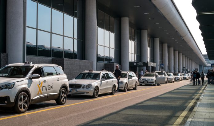 Malpensa airport, Italy - 18 October 2018: Taxi at Malpensa airport. Taxi waiting for passengers. White taxi airport parking