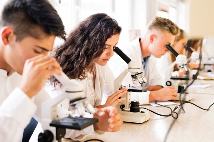 Beautiful,High,School,Students,With,Microscopes,In,Laboratory.