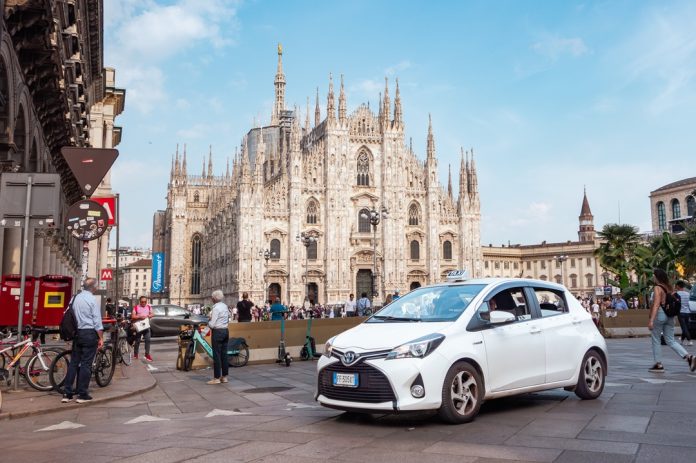 Taxi,In,Milan,,Piazza,Duomo.,Milan,Cathedral,With,People,And